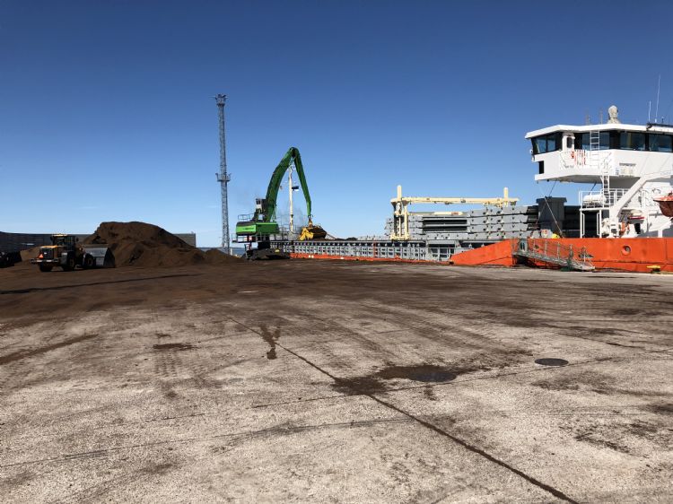 Aan de kade wordt veen in het schip geladen (Estland). Aan de kade wordt veen in het schip geladen (Estland).