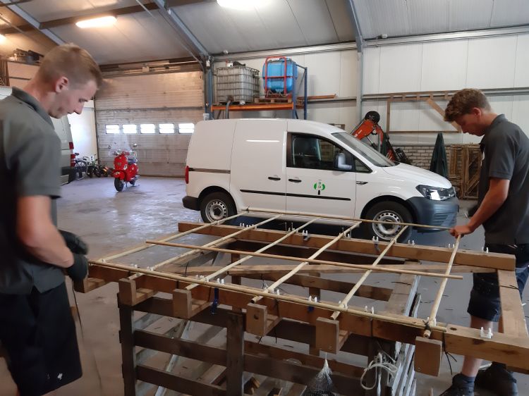 Martijn (links) en Sem (rechts) maken bamboe leirekken. Martijn (links) en Sem (rechts) maken bamboe leirekken.